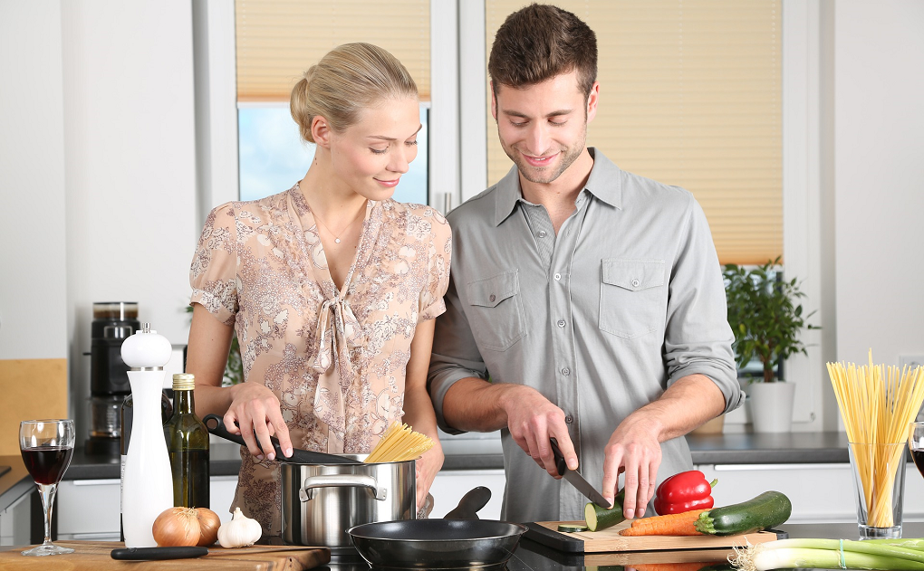 Casal cozinhando. Planejar as refeições semanais em família.